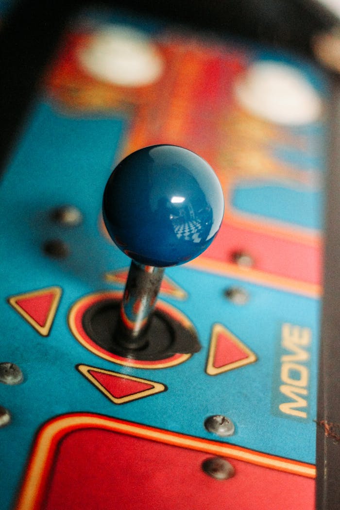 Close-up of a vibrant retro arcade joystick showcasing vintage gaming aesthetics with colorful design.