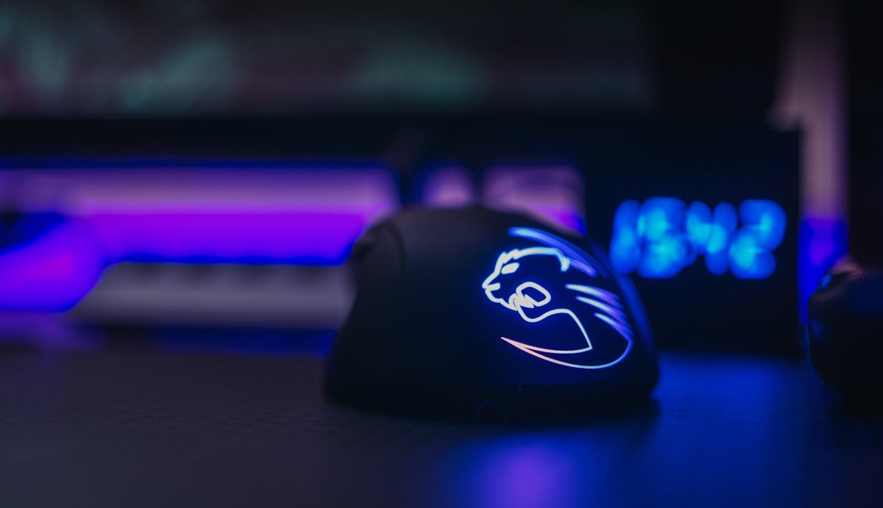 Close-up of an illuminated gaming mouse with LED lights on a dark desk setting.